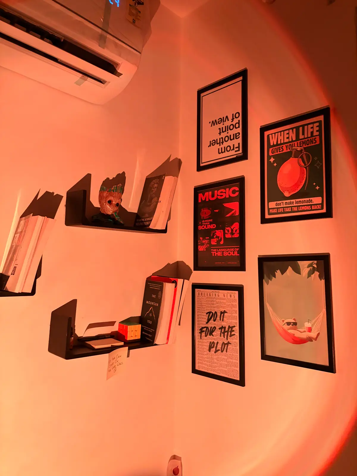 Gallery wall of prints and floating shelves in warm sunset-lamp light